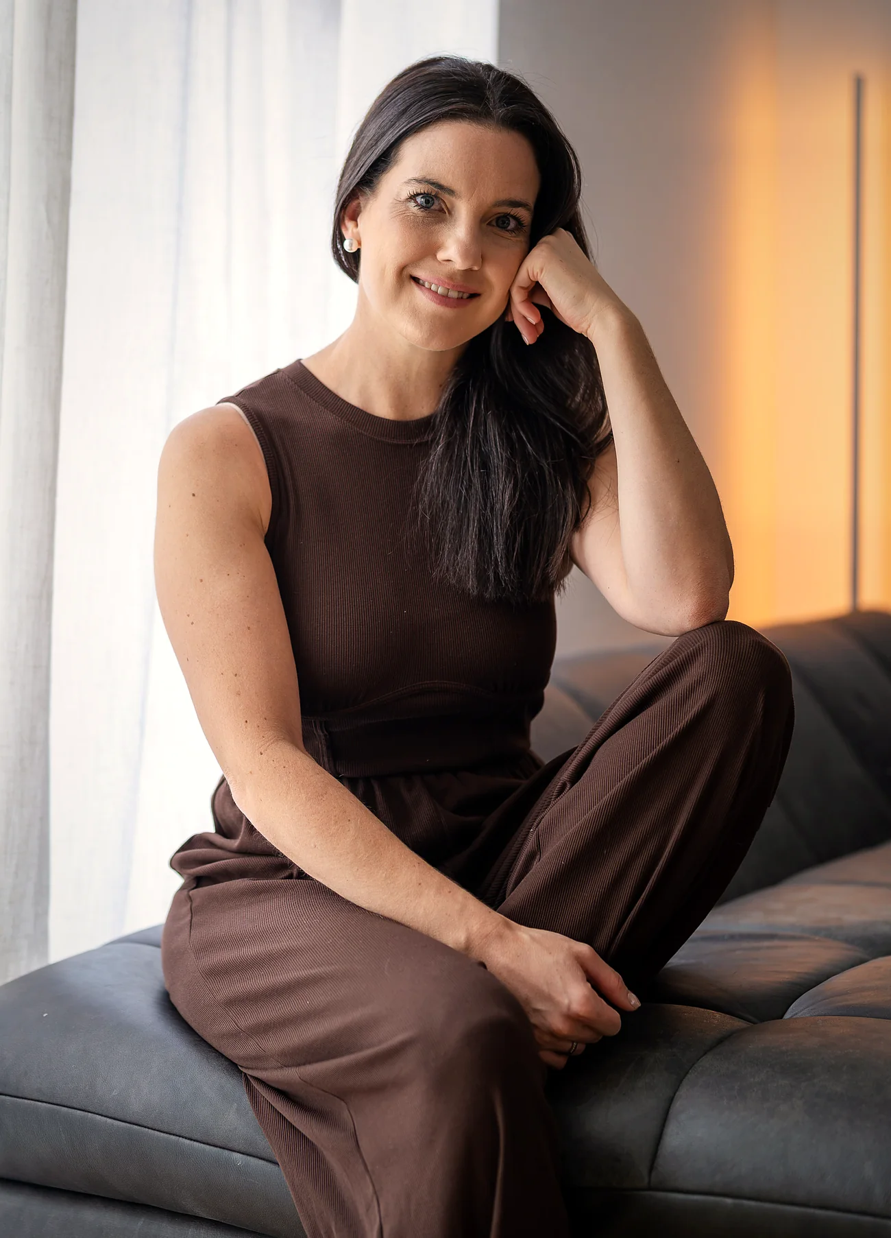 Sabrina Eger auf dem Sofa am Fenster, lächelnd